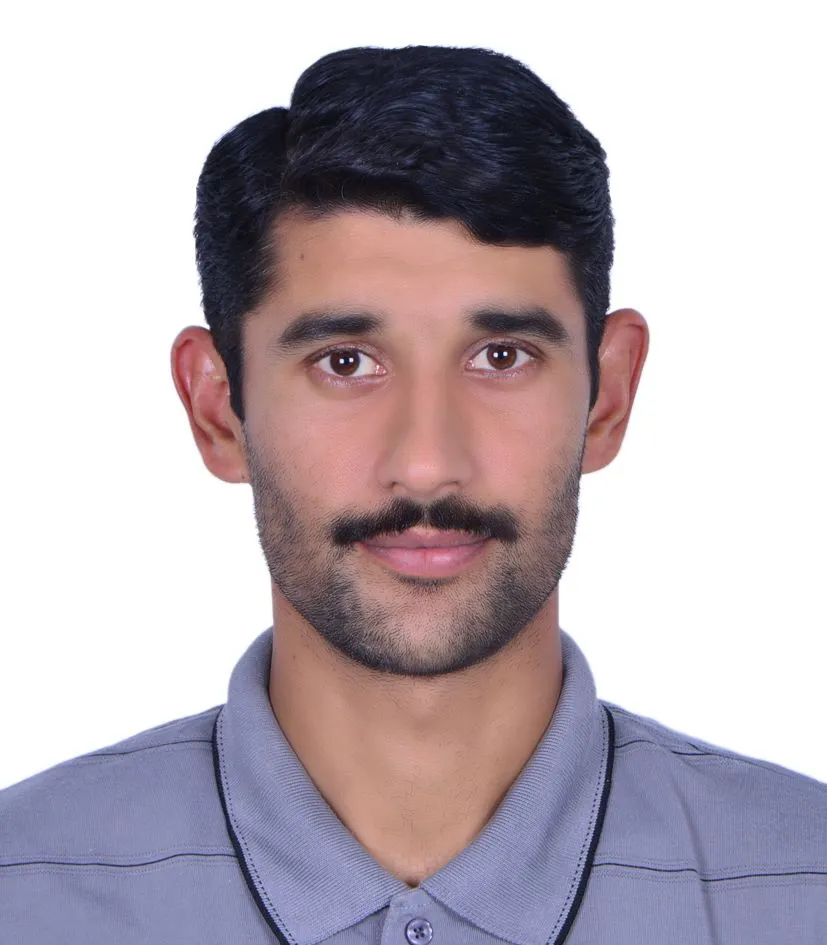 A man with a mustache, featuring a well-groomed beard and quiff hairstyle, wearing a shirt. The image is a headshot that captures his facial features including the forehead, eyebrows, and chin.