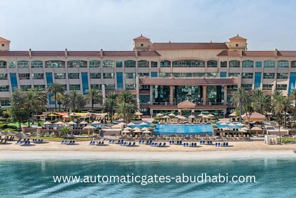 A panoramic view of a beachfront resort at Al Raha Beach, Abu Dhabi, featuring a large pool, sunbeds, palm trees, and stunning views of the Arabian Gulf.