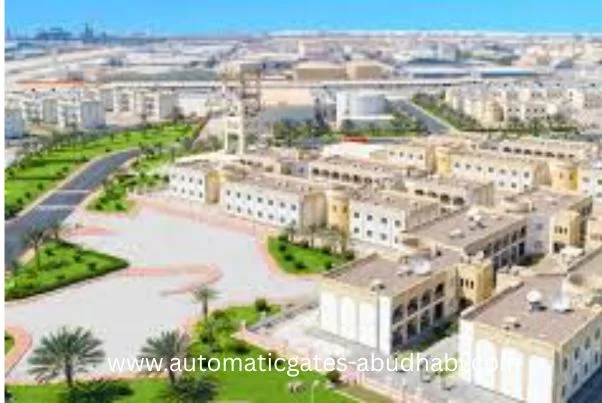 An aerial view of the ICAD residential area in Abu Dhabi, showing neatly arranged buildings, landscaped green spaces, and wide roads.