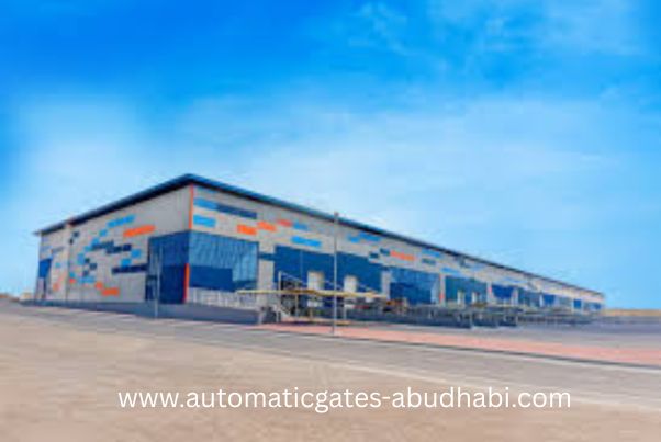 A large industrial warehouse located in KIZAD, Abu Dhabi, featuring a modern design with vibrant colored panels and a clear blue sky in the background.