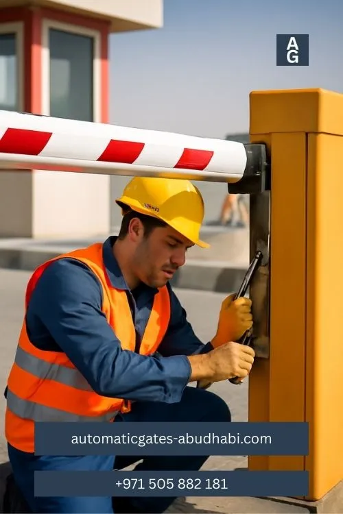 A construction worker repairing an automatic barrier gate at a toll booth in Al Samha.