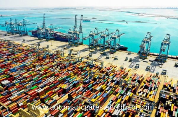 Aerial view of the Khalifa Industrial Zone in Abu Dhabi, showcasing rows of colorful shipping containers and large cranes at the port, with the blue sea in the background.