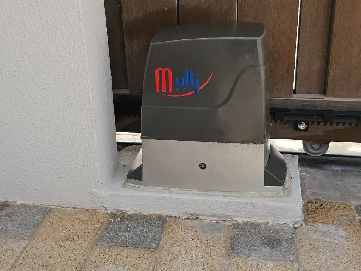 Sliding gate motor mounted beside the gear rack on a villa gate in Abu Dhabi
